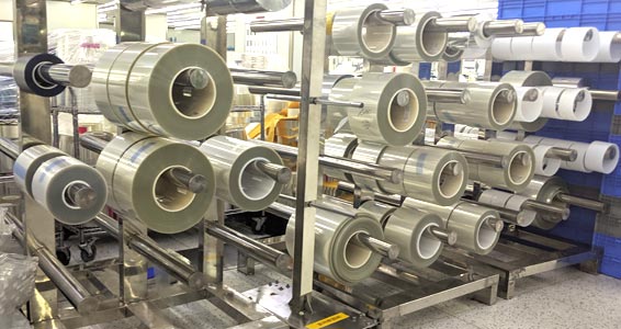 rack with rolls of optically clear adhesives and materials housed in a clean room environment